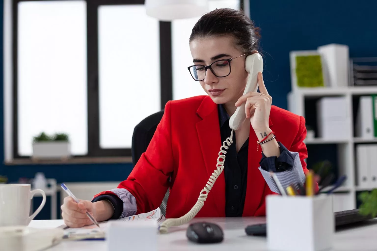 Advogada em atendimento telefônico anotando informações do caso